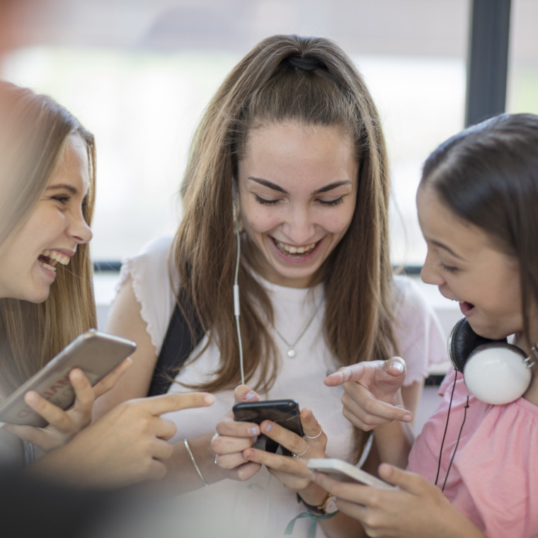 happy-teenage-girls-using-cell-phones-in-school-2022-01-24-23-18-32-utc-760x760.jpg
